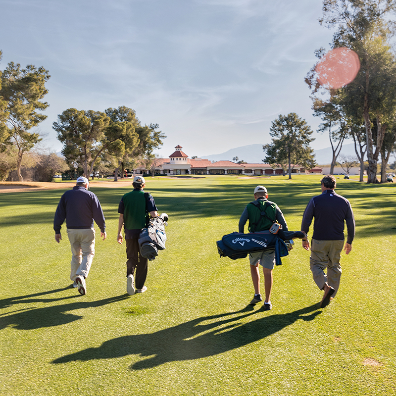 Caddies and players walking toward the clubhouse